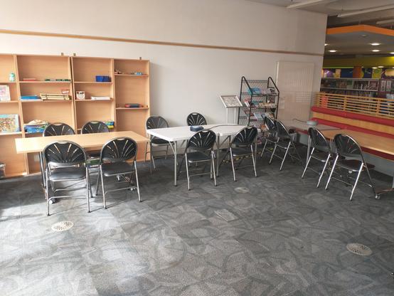 Four tables in a corner of Barry library with twelve chairs around them.