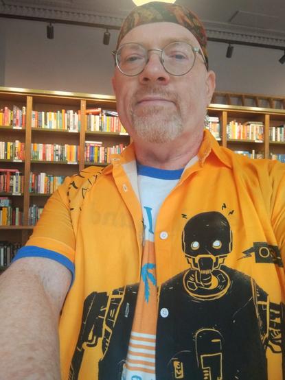 Bright, orange summer shirt with black artwork of robot K-2SO from Rogue One o. The left side