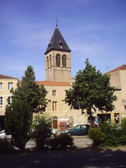 The image appears to feature a building with a tower, likely a church or similar structure, set against a blue sky. There are trees in the foreground and a street scene that includes some parked cars. The overall scene suggests a typical town or village setting. If you need more specific information about the image, feel free to ask!

Image Credits: Wikimedia / L’auteur n’a pas pu être identifié automatiquement. Il est supposé qu'il s'agit de : Zusammen030378~commonswiki (étant donné la revendication de droit d’auteur). / CC BY-SA 3.0