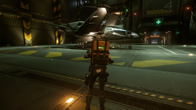Mi personaje, con un traje espacial y una mochila amarilla, de espaldas, frente a su nave espacial una Mustang, aterrizada en el hangar.