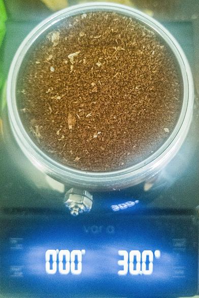 a moka pot coffee basket funnel filled with ground coffee.