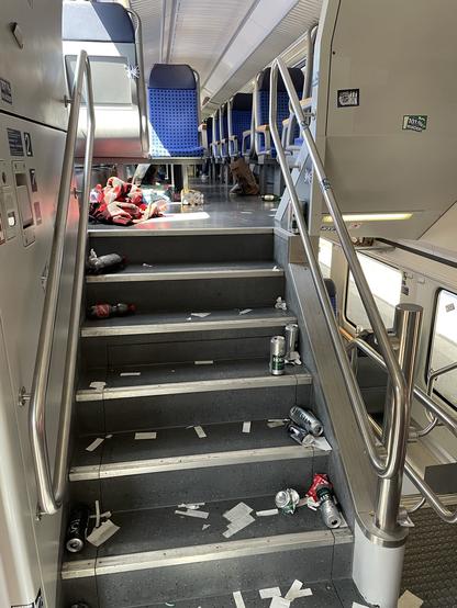 Ein kaputtgeschlagener und vermüllter Innenraum eines Zugwaggons.