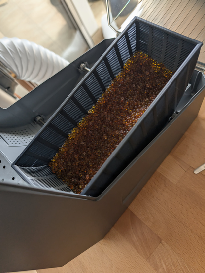Eine aus ASA Filament gedruckter Behälter in einem Filamenttrockner, gefüllt mit orangen Silica Gel Kugel, um diese wieder aufzubereiten.
