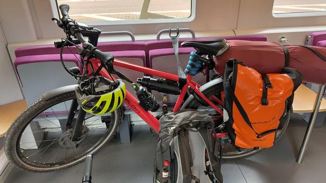 Ein Fahrrad im Fahradabteil. Das Fahrrad trägt Satteltaschen, ein Rucksack steht davor.