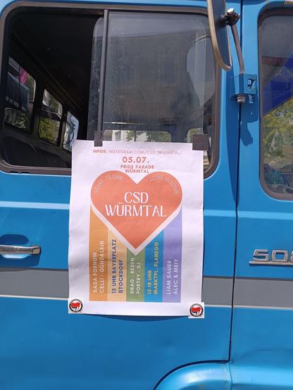 ein Papier Plakat an einem blauen Transporter mit der Aufschrift CSD würmtal in einem roten Herz Start 13 Uhr love is love, und  bachunten Regenbogenstrahlen