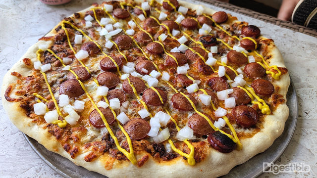 Hot dogs, chili, mustard, and onions on pizza.