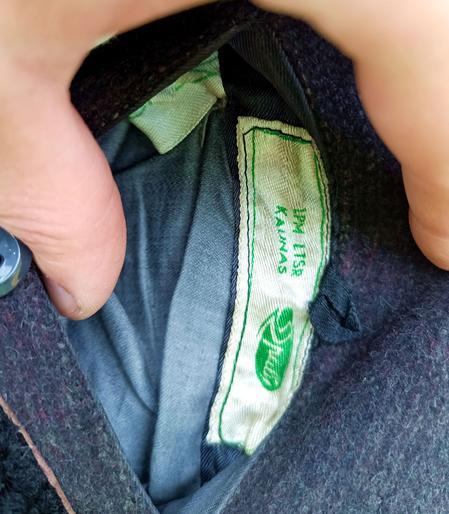 Close-up of the label on the previous coat. It says 1PM LTSR Kaunas and some logo I can't quite make out. There's a cleaning label that has the symbol for "dry clean only" on it.