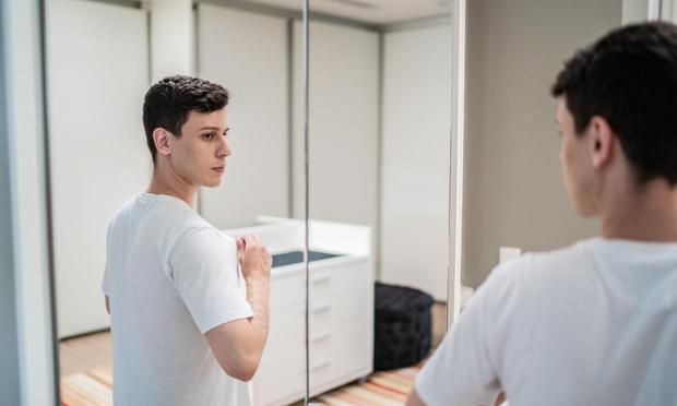 Un joven solo, ante el espejo de su casa (FG Trade via Getty Images)
