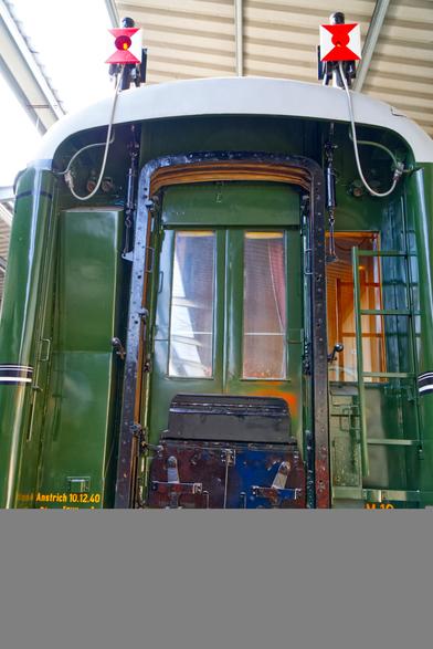 A photo of the back of a green passenger train. Two end of train lights are at the top.