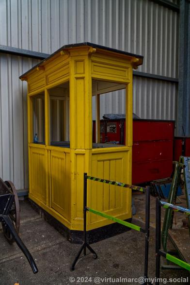 A photo of a small yellow booth.