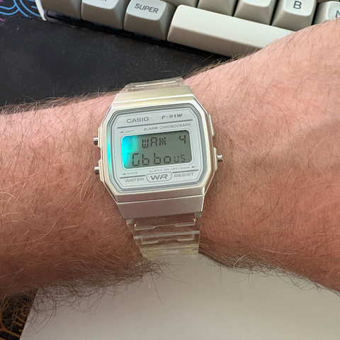 Casio F-91W with Sensor Watch Pro LCD, face isthe Moon Phase face after setting long/lat and a light blue LED illuminated on the left side.