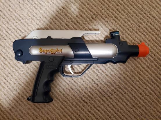 A blue and silver paintball pistol with no hopper. No airtank as it has a manual prime / cocking mechanism for the spring