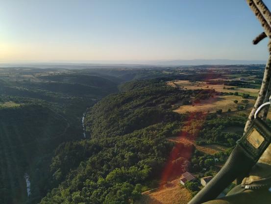 Vue aérienne de la vallée avec le cours d'eau et la forêt de chaque côté.
