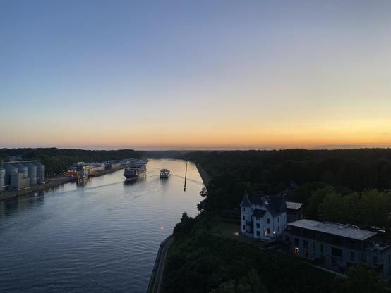 Blau-gelber Sonnenuntergangshimmel über dem Nord-Ostsee-Kanal. Aufgenommen von der Prinz-Heinrich-Brücke. Zwei Schiffe begegnen sich, rechts die Villa Hoheneck.
