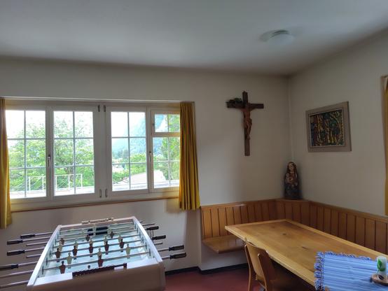 Kleine Stube im Glarner Franziskanerkloster. Neben Madonna und Wandkruzifix steht ein Fussballkicker.
