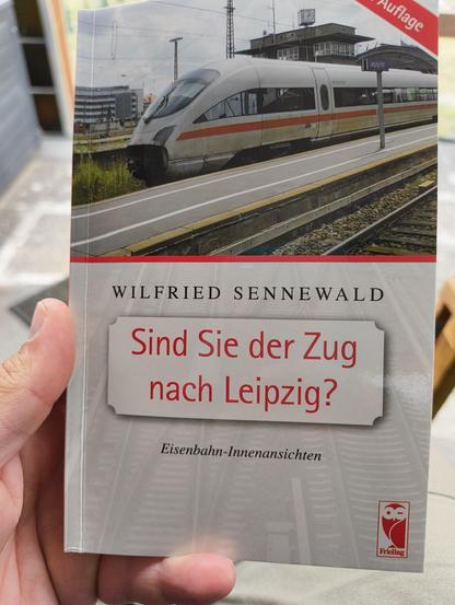 Ich halte das Buch "Sind Sie der Zug nach Leipzig" von Winfried Sennewald in der Hand. Das Cover zeigt einen ICE am Leipziger Hauptbahnhof.