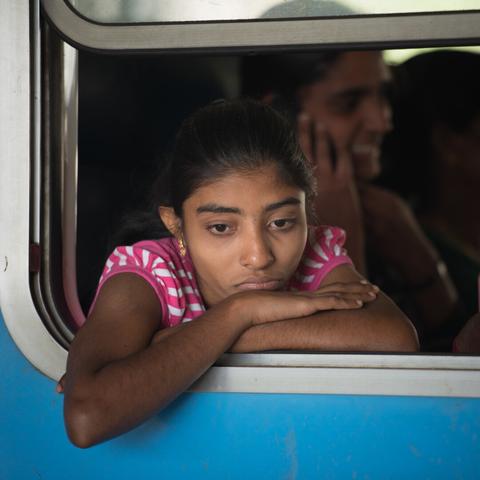 Portrait of a young girl in Sri Lanka, in a blue train.
She is looking outside the train, the window of the train is open and her arm rest on the window pane. She seems to be in her dreams...