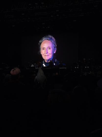 Dark space and a face lit up on a screen.