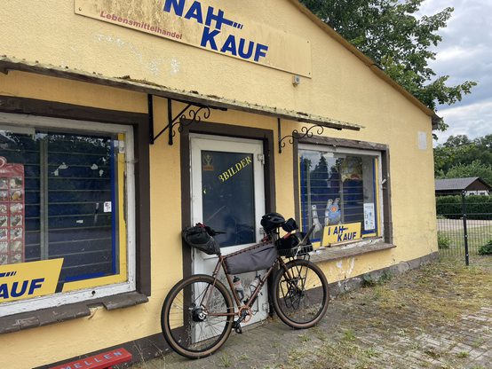 Ein Fahrrad lehnt ab der Tür eines verlassenen Supermarktes.