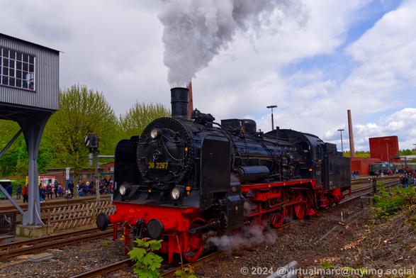 A photo of a steam locomotive, the P1 with the number 38 2267, driving along the rails.