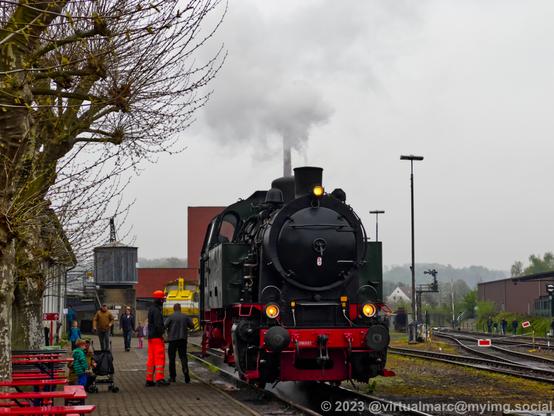A photo of a dark green steam locomotive from the Hespertalbahn. Steam is coming out of the chimney.