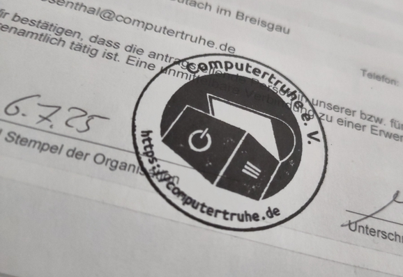 Foto eines kleinen Ausschnitts eines Papierformulars, das unseren Stempel mit Logo und Schriftzug zeigt, der sich auf einer Linie neben dem heutigen Datum befindet, deren Bezeichnung mit "Stempel der Organisation" endet.
