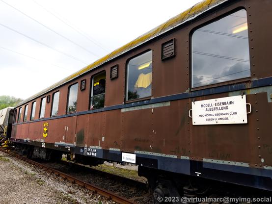 A photo of a railway wagon that contains the model railway. A sign on the outside says:
Modell-Eisenbahn Ausstellung (Model railway exhibition)
MEC-Modell-Eisenbahn-Club Essen und Umgebung