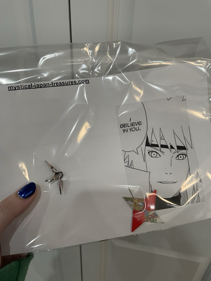 paper cranes and ninja stars with a printed out anime meme
