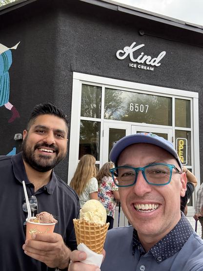 Andrew and Arif holding ice cream while standing in front of Kind Ice Cream.
