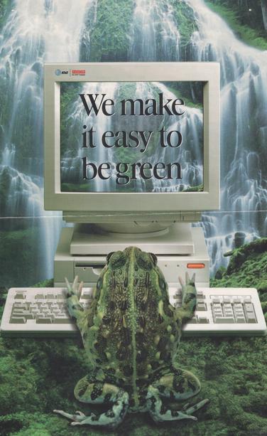 The full original ad, showing the entire CRT monitor, with waterfall wallpaper that is a smaller version of the waterfall behind the computer, with giant black letters filling the screen "We make it easy to be green". Two logo at top left of the monitor: a classic AT&T logo with globe, and red-cap-blocks "NCR" with footer "An AT&T Company". There is a slightly non-perpendicular lighter-colored folding mark just under the bottom edge of the monitor, where the physical ad page was folded in storage.