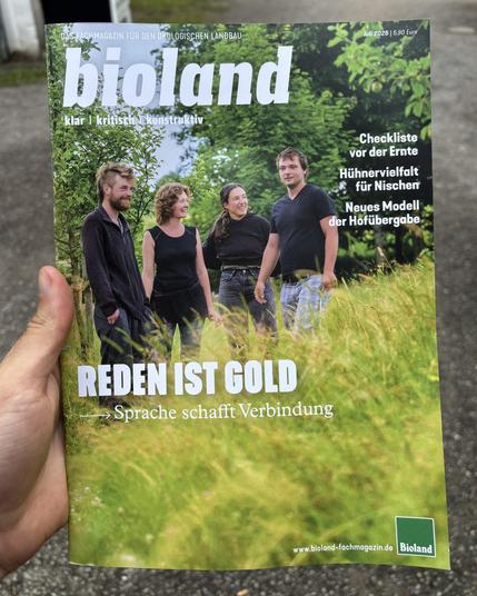 The image shows the cover of a magazine titled "bioland," which is described as a professional magazine for ecological agriculture. The cover is from the July 2025 issue, priced at 5.90 Euros. The main headline on the cover reads "Reden ist Gold," which translates to "Talking is Gold," with a subtitle "Sprache schafft Verbindung," meaning "Language creates connection."

The cover features four people standing in a lush, green outdoor setting, possibly a farm or garden, suggesting a focus on agriculture or ecological themes. The individuals appear to be engaged in conversation or collaboration, reinforcing the theme of communication and connection.

Additional headlines on the cover include:

"Checkliste vor der Ernte" (Checklist before the harvest)
"Hühnervielfalt für Nischen" (Chicken diversity for niches)
"Neues Modell der Hofübergabe" (New model of farm transfer)

The website for the magazine is listed as www.bioland-fachmagazin.de, and the logo for Bioland is displayed at the bottom right of the cover. The overall design and content suggest that the magazine provides practical information and insights for those involved in ecological and sustainable farming practices.
