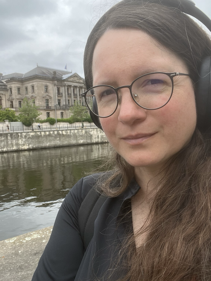 Selfie mit Kopfhörern auf den Ohren vor der Spree