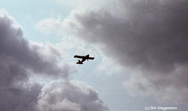 Flugzeug zwischen den Wolken über dem Strand von Harlesiel