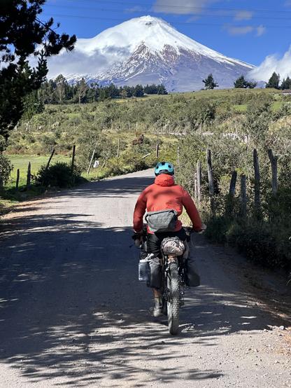 Cycliste sur la piste sur une route devant un volcan