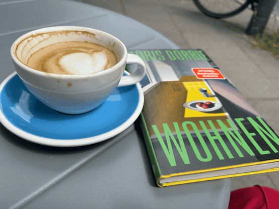 Eine Kaffeetasse und ein Buch mit dem Titel "Wohnen" von Doris Dörrie