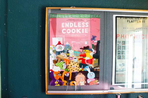 Photo of the marquee poster for the film "Endless Cookie" inside The Princess Theatre, depicting a number of colourful, eclectically designed cartoon characters chilling together.