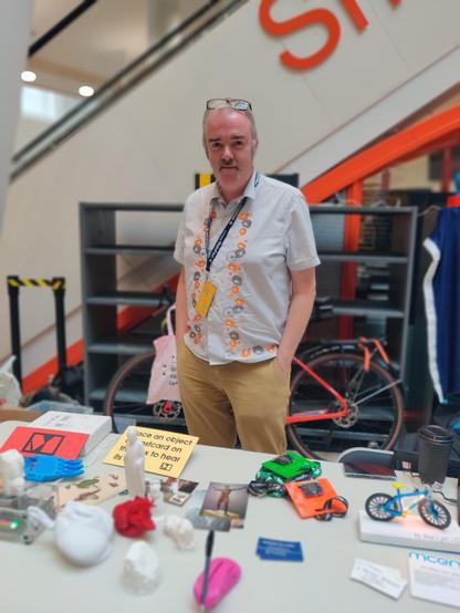 Adrian stands behind a white table facing the camera. On the table are a collections of 3D printed items and postcards for Museum in a Box. 

Adrian can be found here on Mastadon - https://social.mcqn.com/deck/@amcewen@mastodon.me.uk