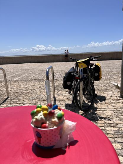 Une glace avec de M&M’s deux vélos et du ciel bleu au bord de la mer