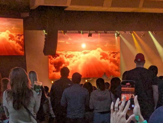 A zoomed in view of the main screen on the stage showing an orange sun and clouds.