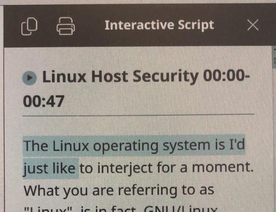 A photo of a computer screen displaying a read-along script for a video. Under the "Linux Host Security 00:00-00:47" heading, it says "The Linux operating system is I'd just like to interject for a moment. What you are referring to as 'Linux', is in fact, GNU/Linux..."