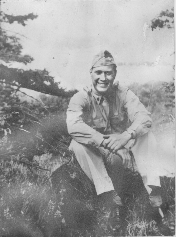 1/LT Jack Sonstein, in 1943. Probably on his honeymoon at Niagra Falls. He is seated on some rocks, there are tree branches to the left of him and possibly a falloff into the river to the right of him. The photo is greyscale, and faded with exposure to sunlight.