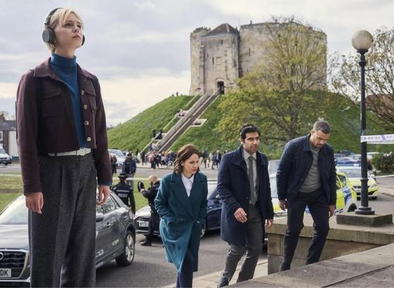 The main characters from the TV show ‘Patience’ arriving at a crime scene.