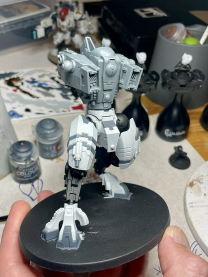 A half-assembled, half-painted t’au riptide battlesuit.