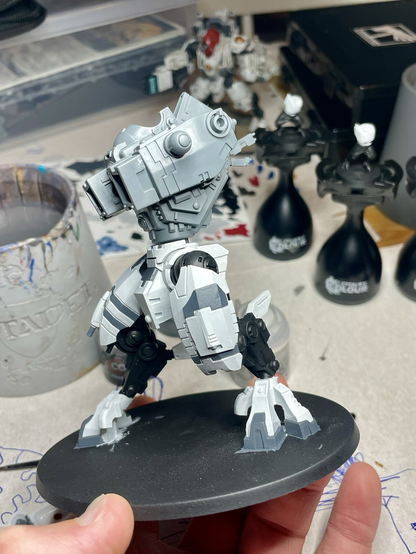 A half-assembled, half-painted t’au riptide battlesuit, side view.