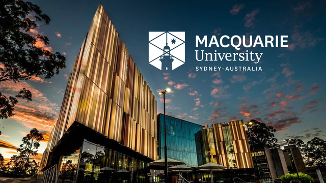 A sharp-edged building that is being imaged from the front facade, whilst the sun has set. The words "Macquarie University - Sydney Australia" are annotated.