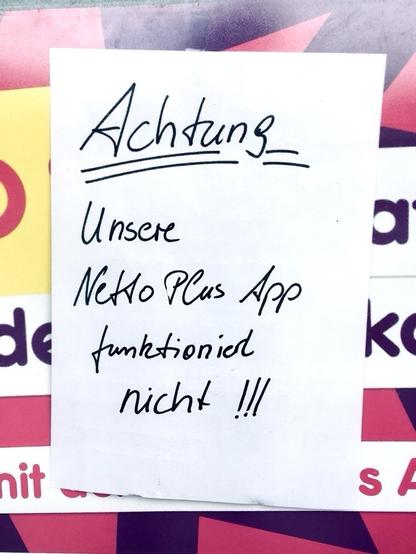 Ein handgeschriebener Hinweis mit der Aufschrift "Achtung"  und informiert darüber, dass die "Nettoplus App" nicht funktioniert, unterstrichen mit 3 Ausrufezeichen. Der Hinweis wird auf einem bunten Hintergrund angezeigt.
--
A handwritten notice that says "Achtung" (Attention) and informs that the "Nettoplus App" is not functioning, emphasized with 3 exclamation marks. The notice is displayed on a colorful background.