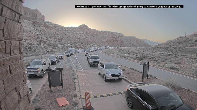 Cars line up to enter the park at the entrance station at dawn.
