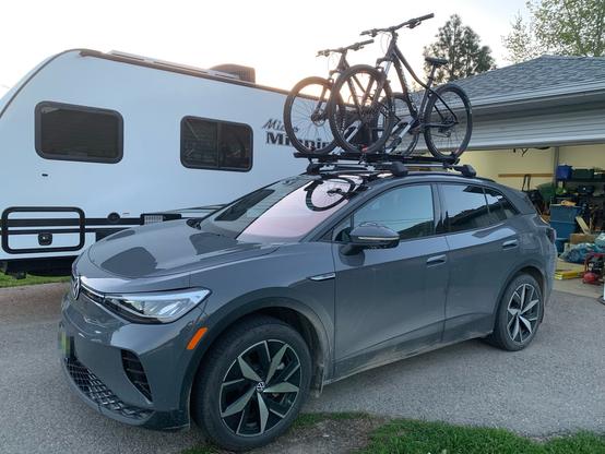 Photo of a grey VW ID.4 electric SUV with two mountain bikes mounted on a roof carrier.