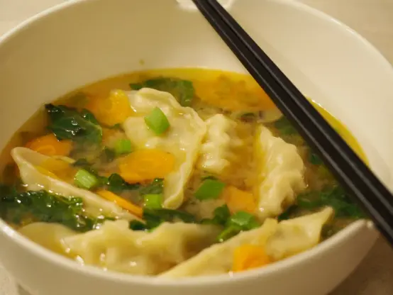 Eine klare Suppe mit Miso, Gemüse und Gyoza