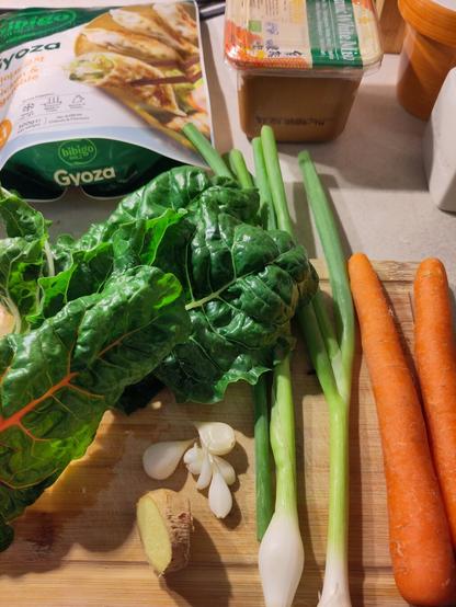 ein paar der Zutaten für die Suppe. darunter frischer Knoblauch und Mangold aus dem Garten, Ingwer, Karotten, Frühlingszwiebel, Misopaste und eine Packung Gyoza
